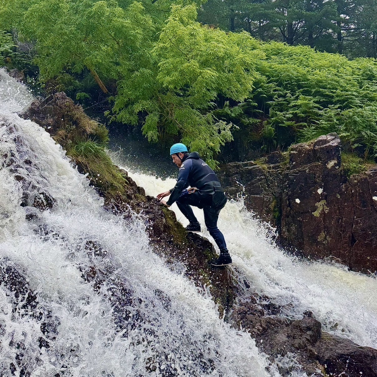 a person ascending a waterfall climb