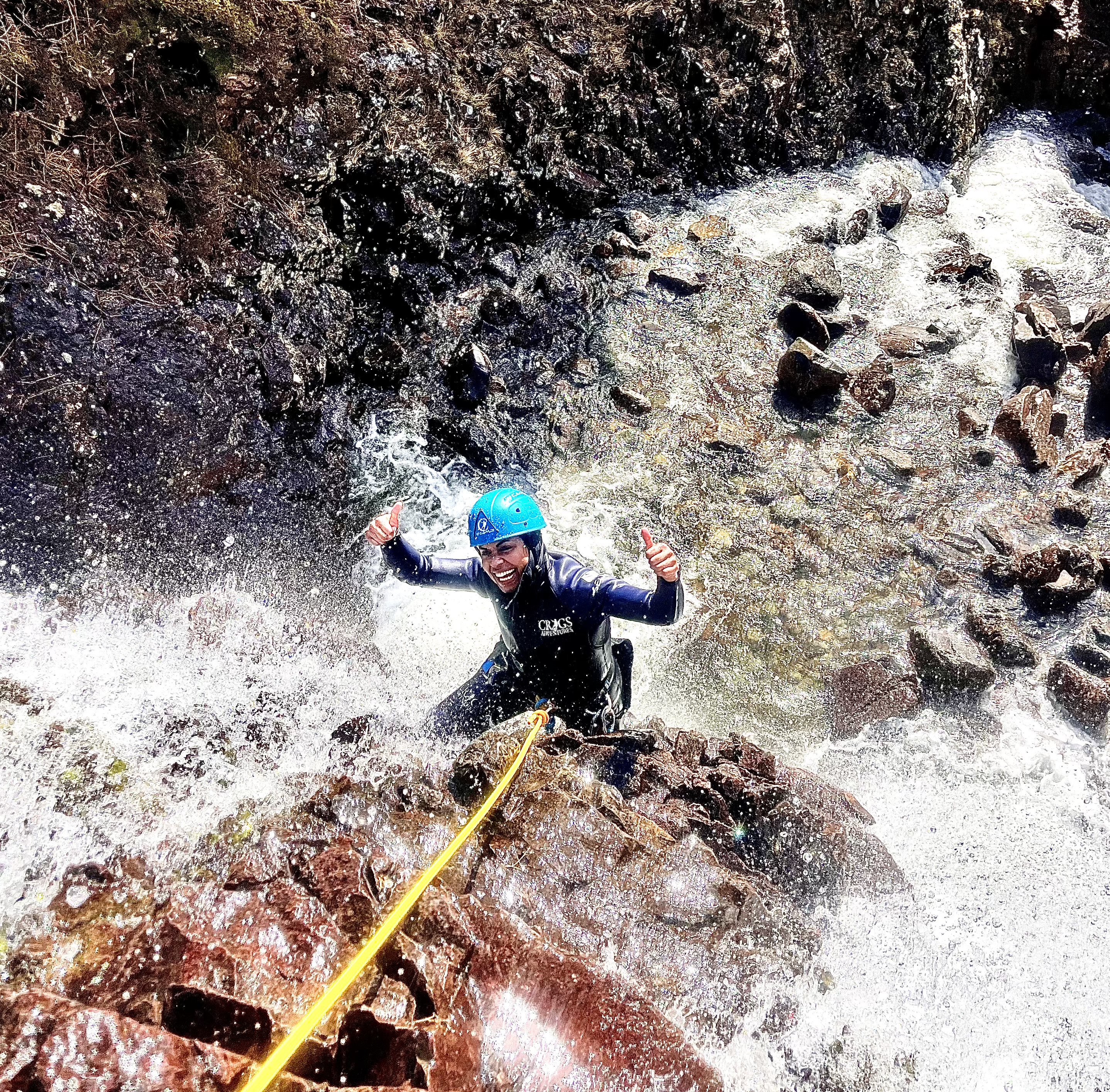 person climbing up a big waterfall in langdale, lake district