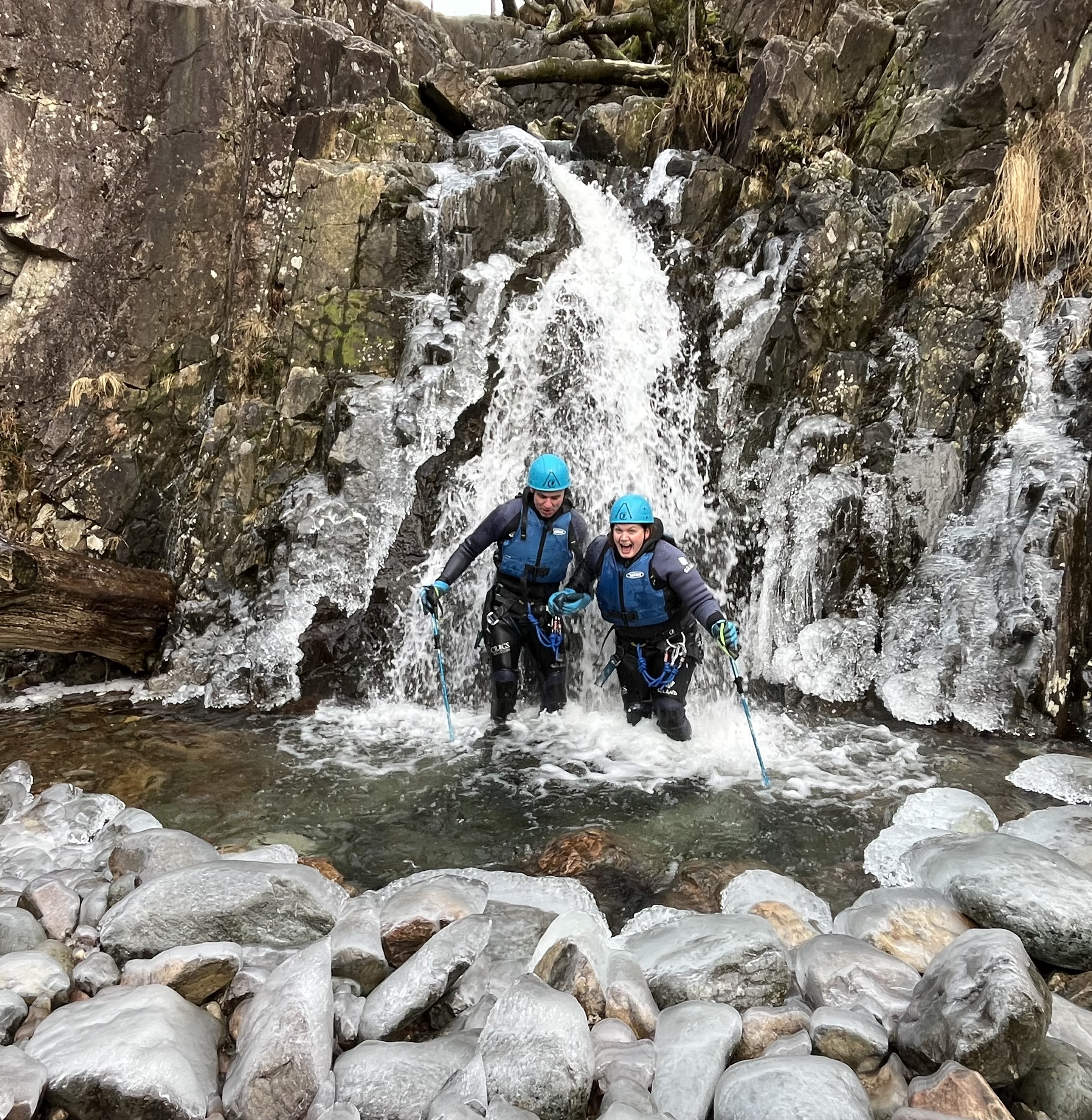 a couple doing a canyoning activity in an organised group in the Lake District in Winter