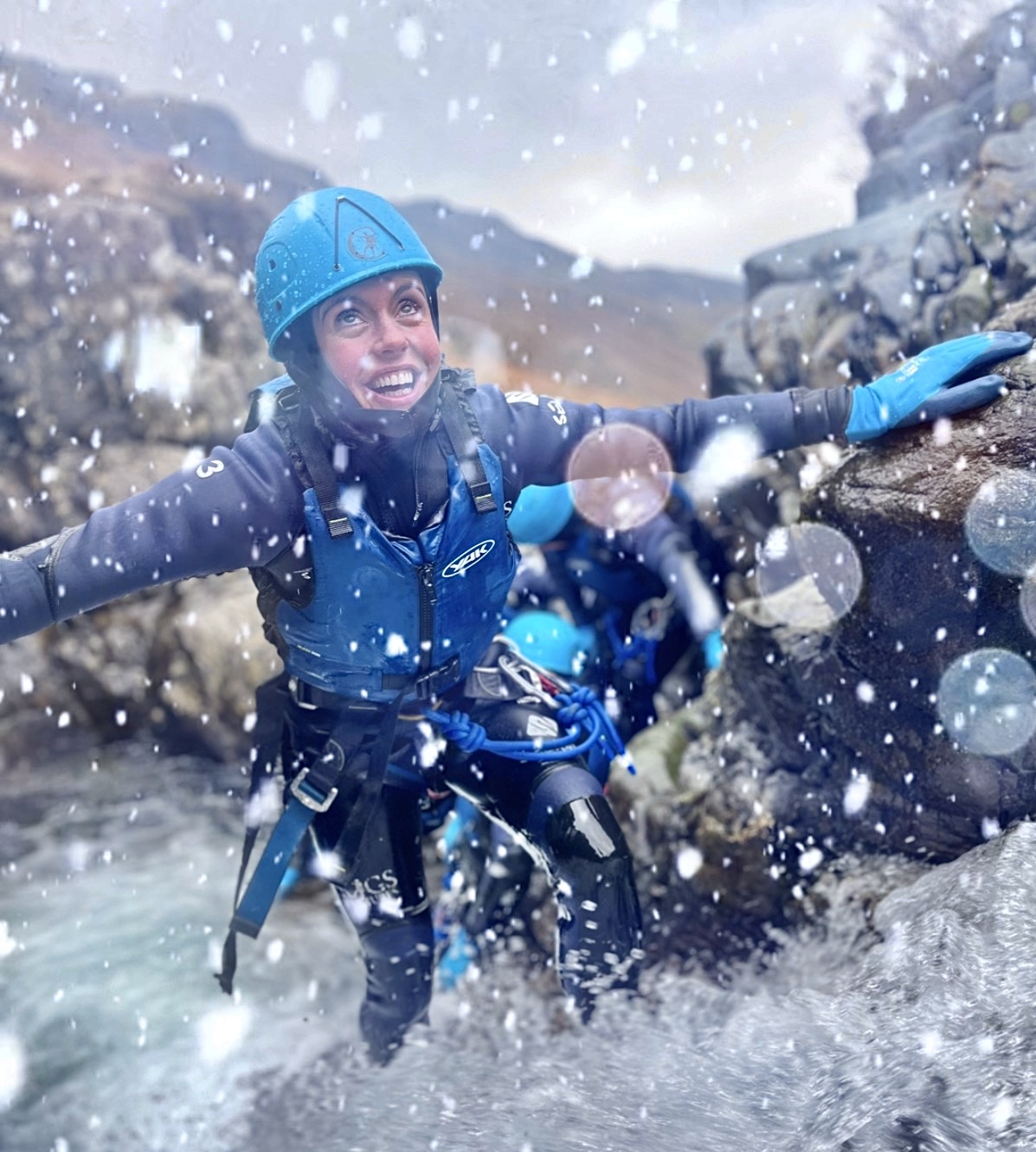 a woman ghyll scrambling in winter