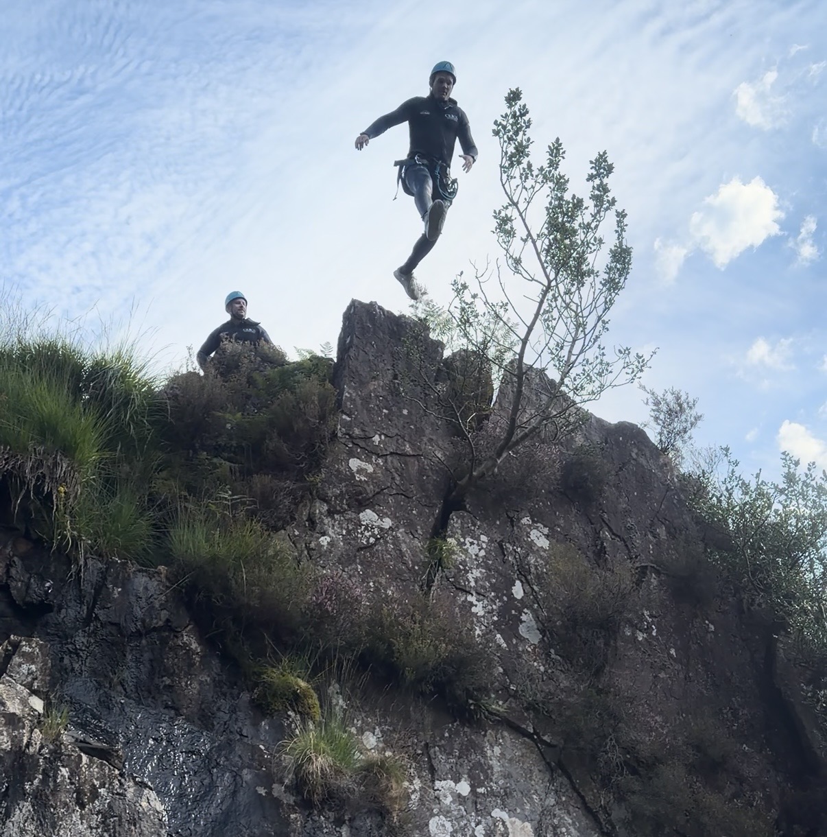 a person that has just stepped off a cliff, mid jump on a ghyll scramble