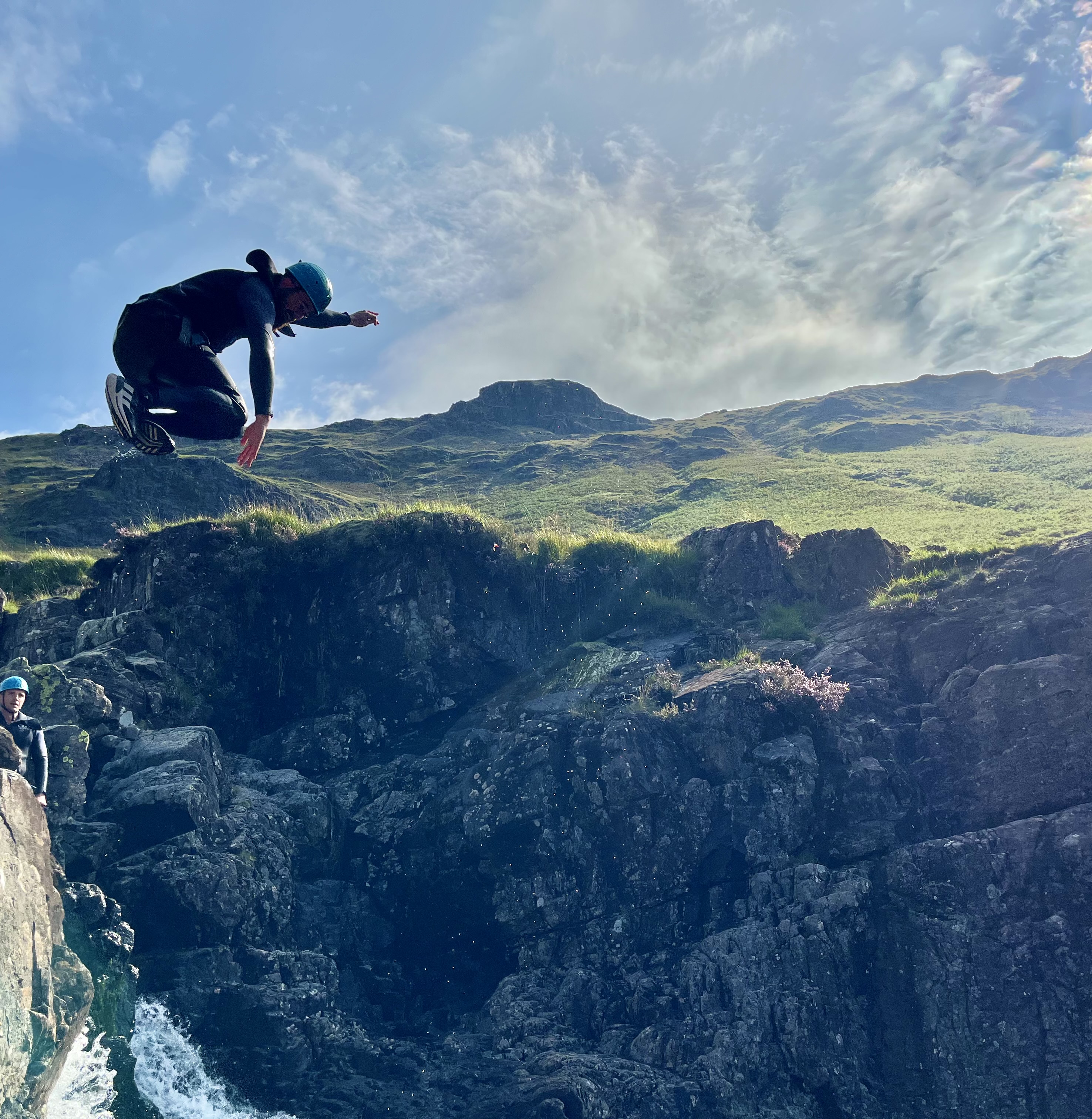 a person showboating as they jump into a mountain stream